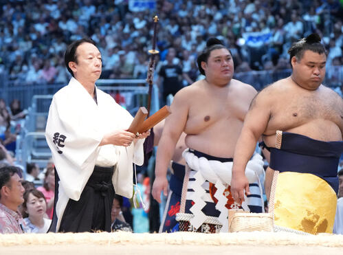 横綱土俵入りで拍子木をたたく呼び出しの克之（左）（撮影・森本幸一）