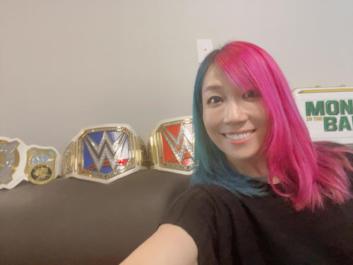 これまで獲得したWWE女子主要王座ベルトやマネー・イン・ザ・バンク女子ラダー戦で獲得したブリーフケースを公開するアスカ（C）2022 WWE, Inc. All Rights Reserved.