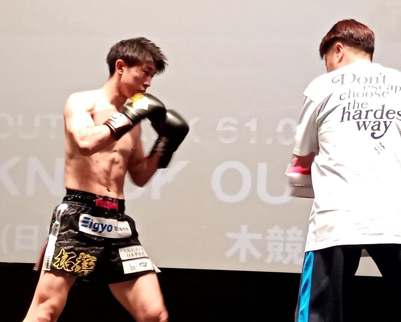 ミット打ちをする成尾拓輝（左）