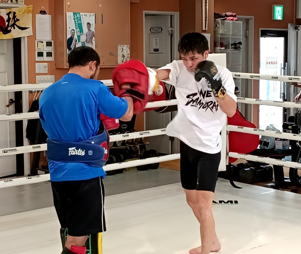 ミット打ちをする玖村将史（右）