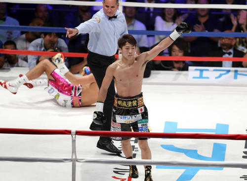1回、マクドネル(後方)からダウンを奪い、左拳を突き上げる井上尚(撮影・狩俣裕三)