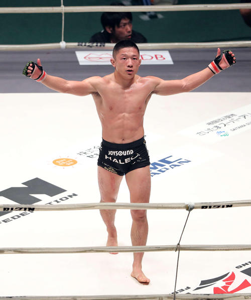 判定前、勝利を確信し手を挙げる堀口恭司(撮影・鈴木正人)