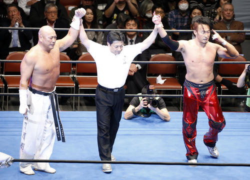 第7試合 勝利を決めガッツポーズする、新崎人生(左)と丸藤正道(撮影・河田真司)