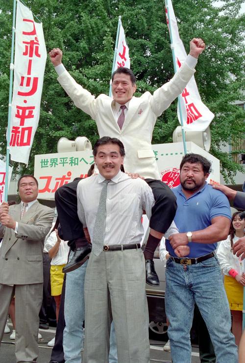 「スポーツ平和党」から参議院選挙に出馬したアントニオ猪木は馳浩（手前）、マサ斉藤（右）らに担がれてポーズを決める。左はガッツ石松（1989年7月日撮影）