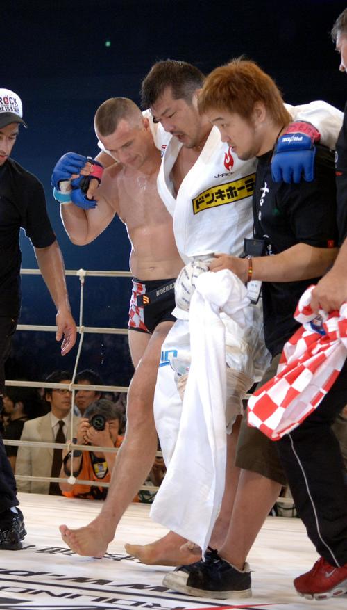 ミルコ・クロコップ（左）の肩を借りてリングを降りる吉田秀彦。右は中村和裕（PRIDE無差別級GP、2006年7月1日撮影）