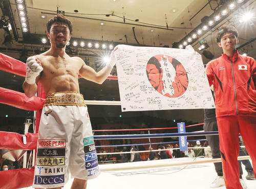 試合に勝利し、日の丸の寄せ書きを披露する八重樫（左）（撮影・大野祥一）