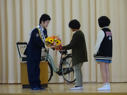 城陽警察署のイメージポリスとして、母校の久世小学校を訪問した拳四朗。女子児童から歓迎の花束を受け取る（撮影・加藤裕一）