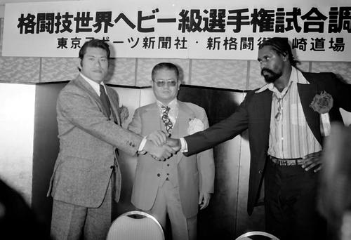新日本プロレス異種格闘技戦調印式　ウィリー・ウィリアムス（右）と握手をかわすアントニオ猪木。中央は特別立会人の梶原一騎氏（1980年2月撮影）