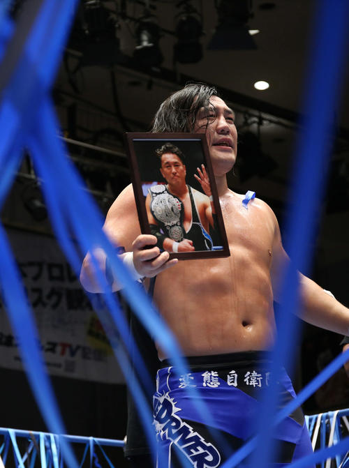 故青木篤志の写真を手に、観客にあいさつをする佐藤（撮影・河田真司）