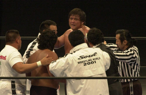 無効試合の裁定を下した藤波辰爾社長（手前右から2人目）をにらみつける橋本真也。手前左から2人目は長州力
