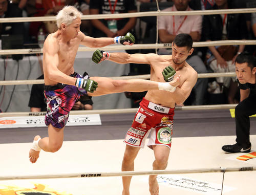 石渡伸太郎対佐々木憂流迦　第1R、石渡伸太郎（右）をいきなり跳び蹴りで襲う佐々木憂流迦（撮影・狩俣裕三）