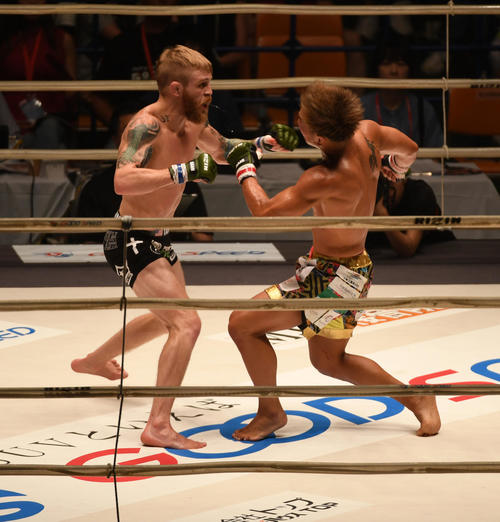 3R、祖根寿麻（右）にパンチを放つジャスティン・スコッギンス（撮影・前岡正明）