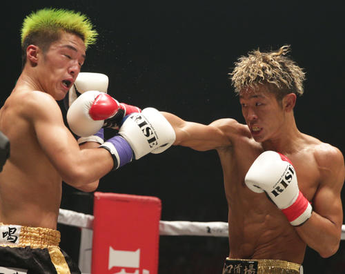 田丸（左）に右ストレートを浴びせる鈴木（撮影・中島郁夫）