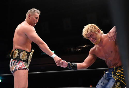試合後、悔し涙を流すSANADA（右）と握手を交わすオカダ・カズチカ（撮影・滝沢徹郎）
