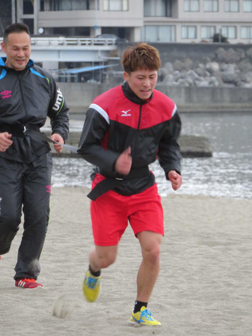 高村トレーナー（左）を引っ張りながら砂浜を走る井上尚（2018年2月19日撮影）