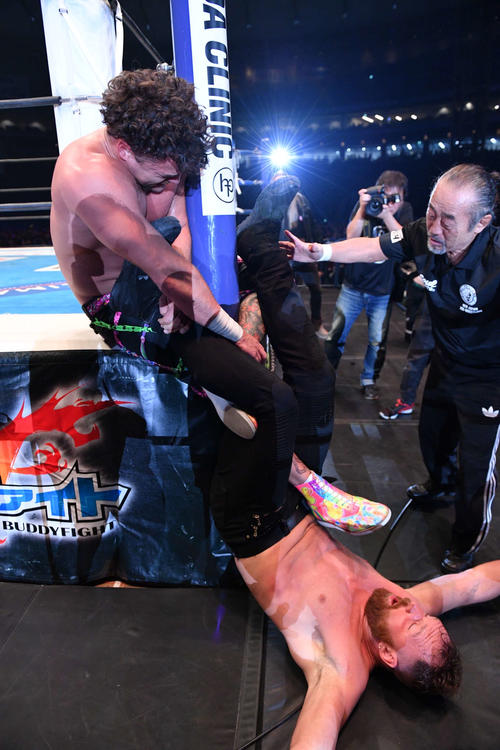 第4試合　IWGP　USヘビー級選手権試合　ジョン・モクスリー対ジュース・ロビンソン　ジュース・ロビンソン（上）の脚を攻めるジョン・モクスリー（撮影・滝沢徹郎）