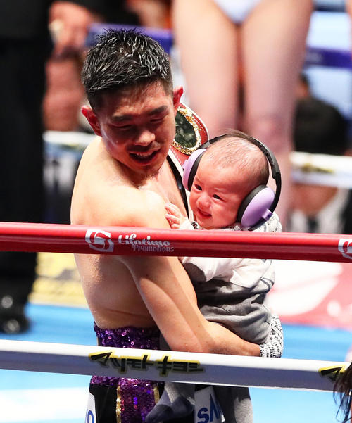 井岡は防衛に成功しリング上で長男を抱き笑顔を見せる（撮影・足立雅史）