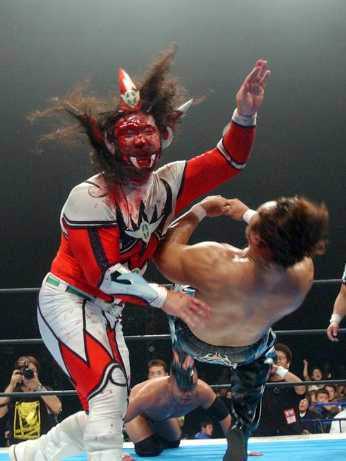 マスクをはがされ血まみれになった獣神サンダーライガー（左）は竹村豪氏に怒りの掌打（2003年10月18日撮影）