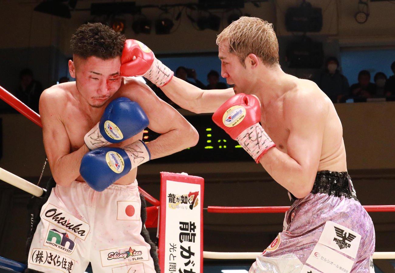 富岡（左）に右ストレートを浴びせる吉野修一郎（撮影・中島郁夫）