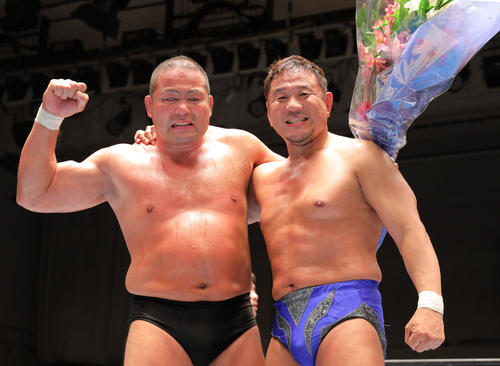 引退セレモニーで永田裕志(右)と肩を組み笑顔で写真に納まる中西(撮影・河田真司)