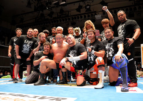 引退セレモニーで新日本プロレスの選手たちと写真に納まる中西(中央)(撮影・河田真司)