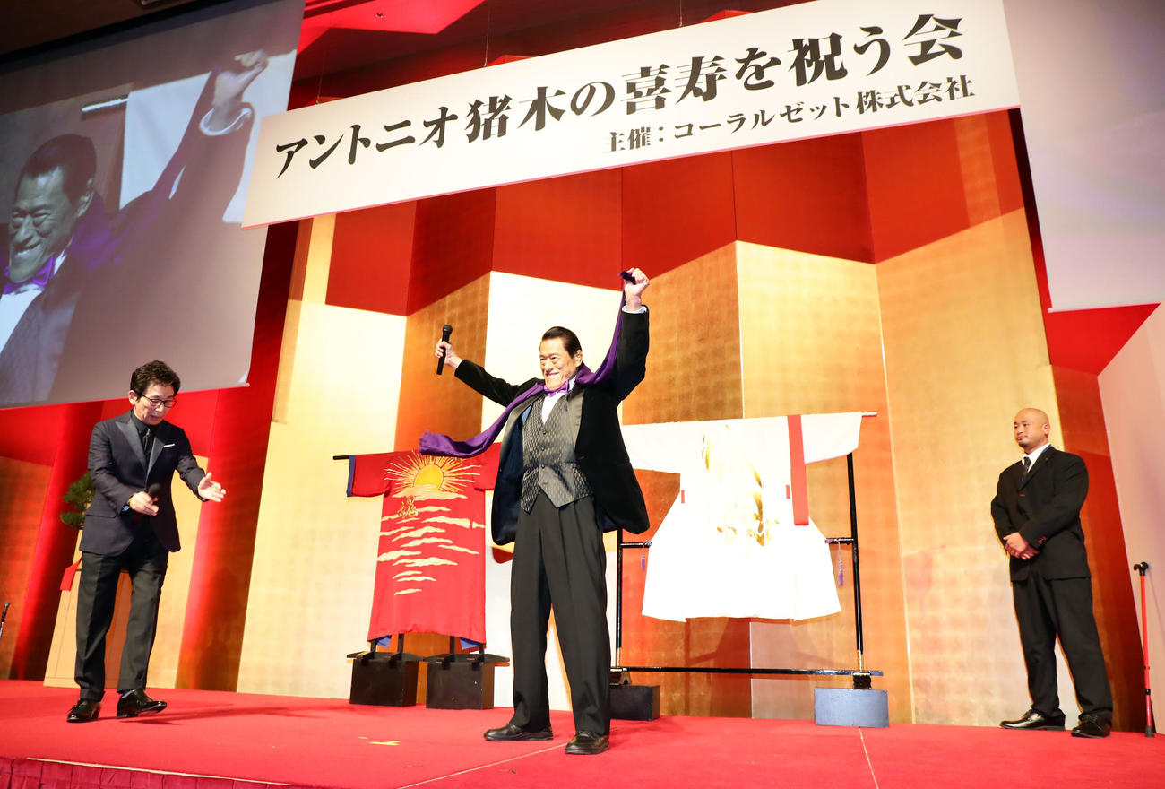 「アントニオ猪木の喜寿を祝う会」で、古舘伊知郎アナウンサー（左）の呼び込みで登場したアントニオ猪木氏（中央）（撮影・浅見桂子）