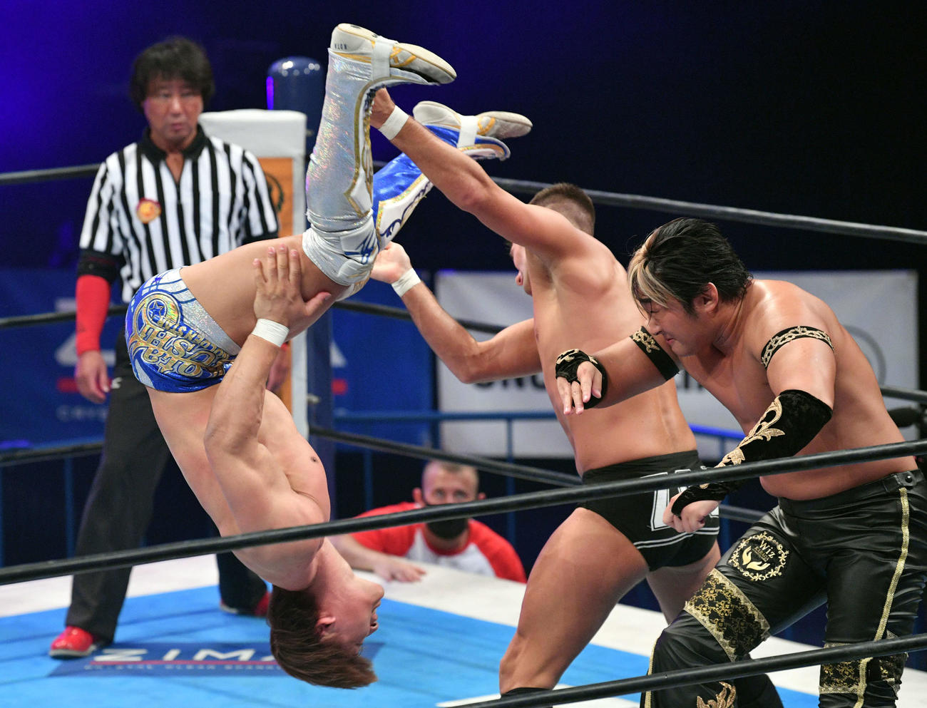 真壁、永田、飯伏、棚橋組対DOUKI、鈴木、ザック・セイバーJr、タイチ組　ザック・セイバーJr（中央）とタイチ（右）に蹴りを見舞う飯伏（撮影・滝沢徹郎）