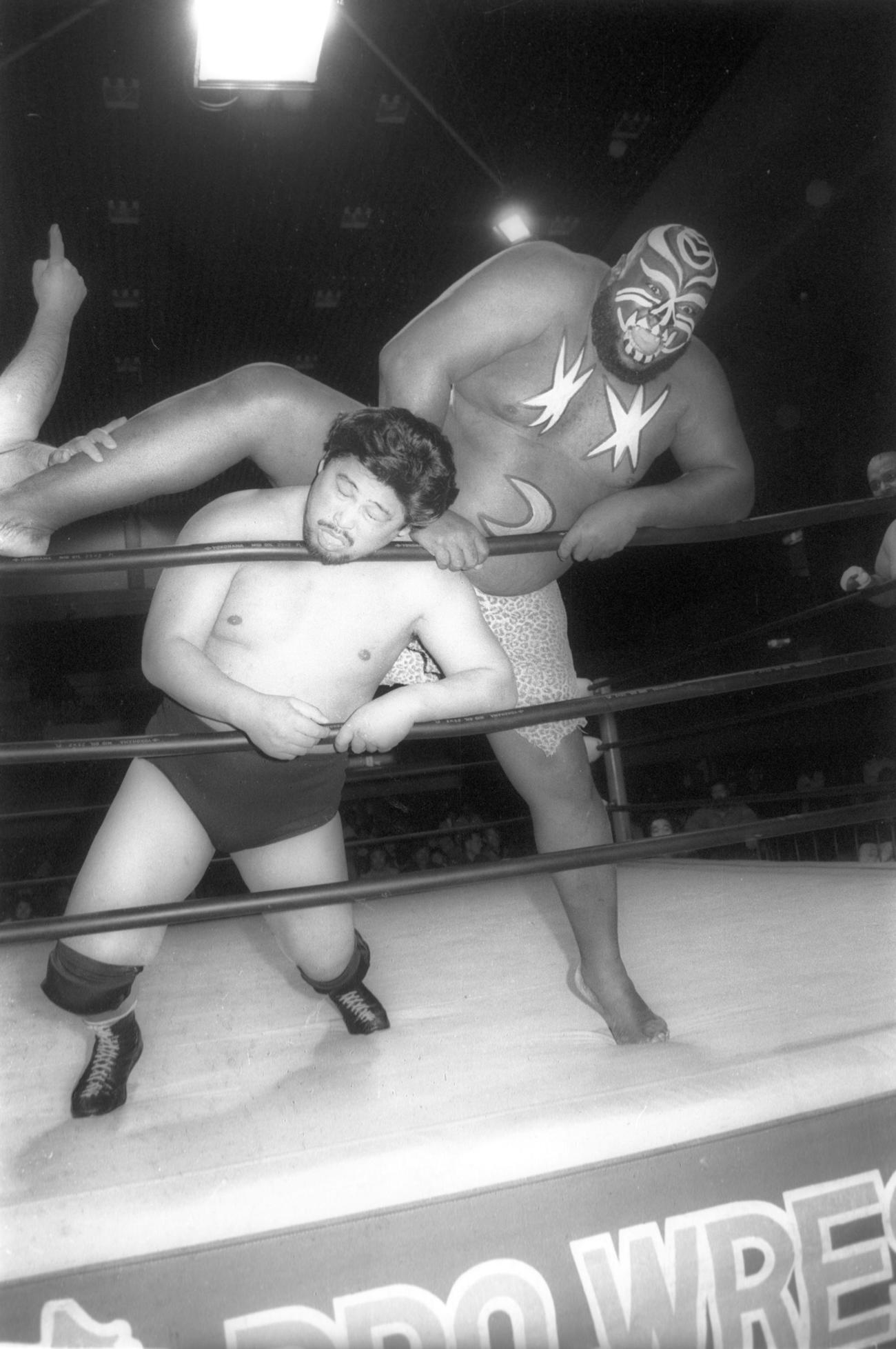 89年2月、全日本プロレスで谷津（手前）の首をロープに押しつけ後頭部へキックを浴びせる初代ジャイアント・キマラ