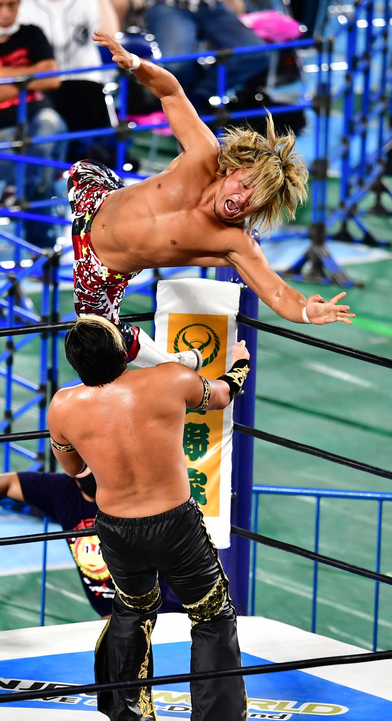 ホワイトコーナーから振り向きざまにタイチ（手前）にプランチャを浴びせる棚橋（撮影・小沢裕）