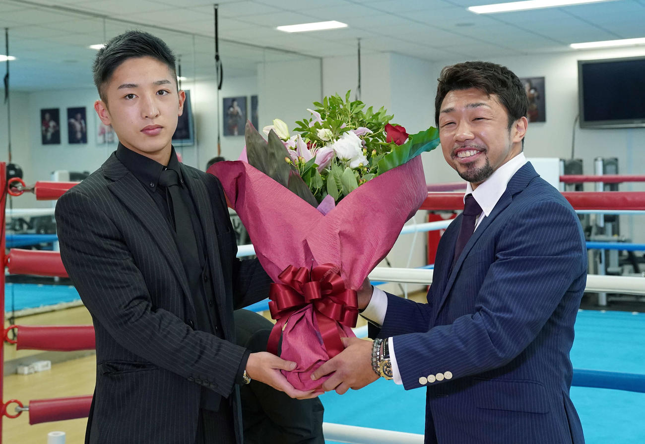 トレーナーとして担当する中垣（左）から花束を贈られ笑顔の八重樫（大橋ジム提供）