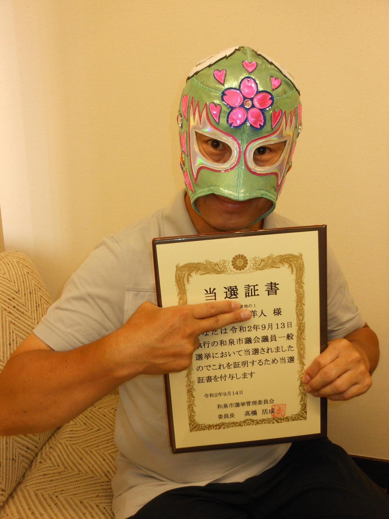 大阪・和泉市議選で3選を果たしたスペル・デルフィンは当選証書を手に取材に応じる