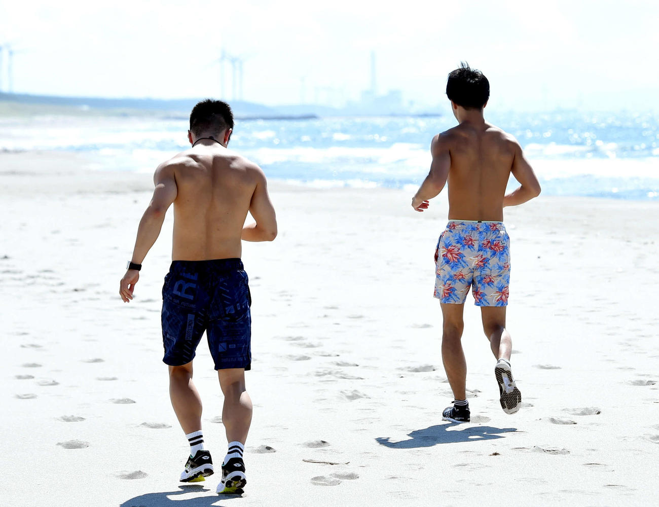 砂浜でランニングをする田中恒（左）と田中亮（撮影・相沢孔志）