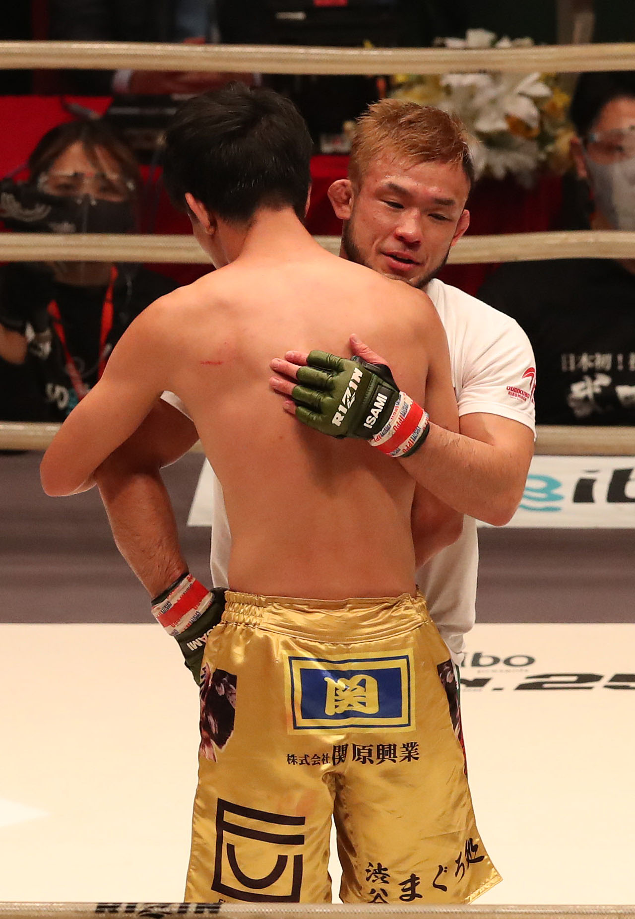 RIZIN.25　第9試合、扇久保博正対滝沢謙太　滝沢謙太（手前）を判定で下して、抱き合って健闘をたたえ合う勝者の扇久保博正（撮影・白石智彦）