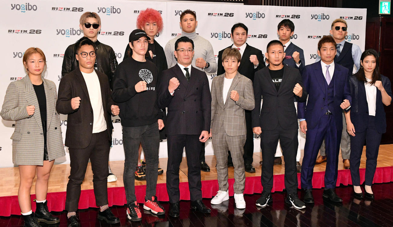 RIZIN26の記者会見で記念撮影する選手ら。前列左から浅倉、太田、井上、RIZIN　CEOの榊原伸行氏、浜崎、元谷、所、あい、後列左から平本、佐々木、スダリオ剛、ミノワマン、滝沢、萩原（撮影・滝沢徹郎）