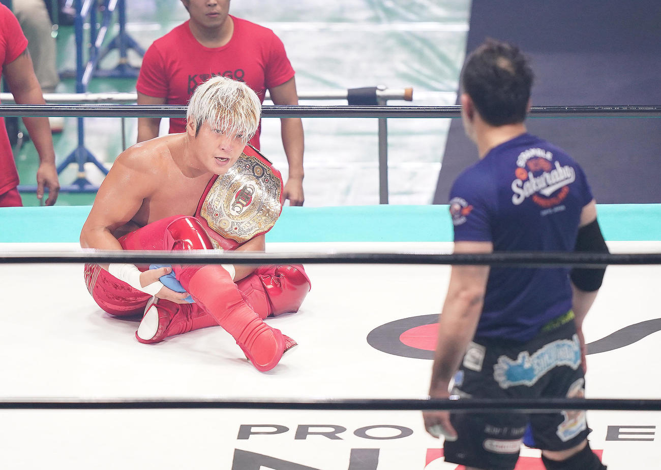 桜庭（右）に勝利し、防衛に成功した拳王は、チャンピオンベルトを肩に座り込む（撮影・菅敏）