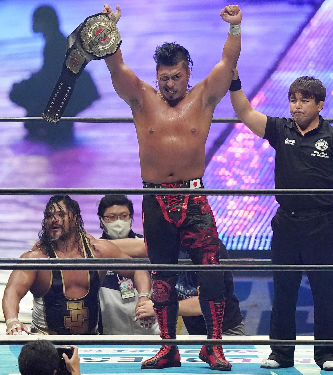 ジェフ・コブ（左下）に勝利し、NEVER無差別級王座の防衛に成功した鷹木信悟は、ベルトを手にガッツポーズを見せる（撮影・菅敏）