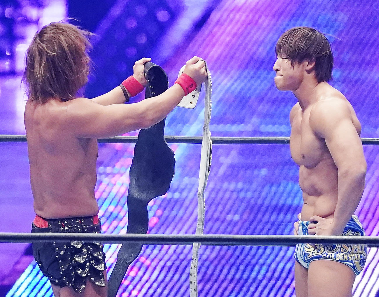 内藤（左）から2本のIWGPチャンピオンベルトを手渡され飯伏（撮影・菅敏）