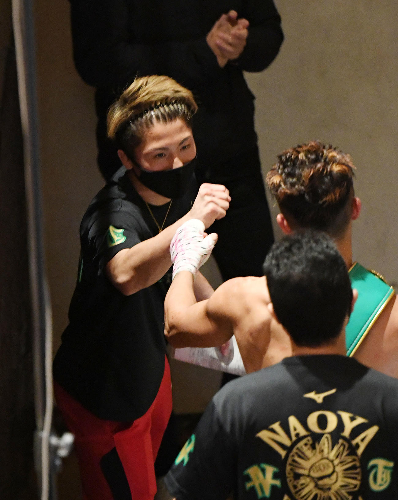 試合に勝利した弟・拓真（右）とタッチをかわす井上尚（撮影・横山健太）