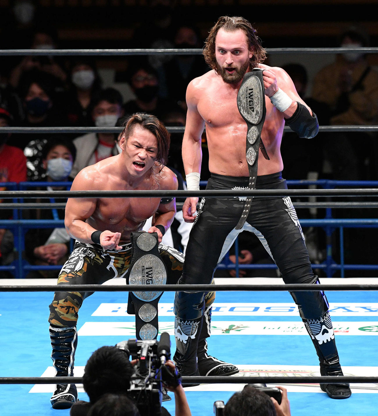 タイトル奪取に成功しベルトを手にポーズを決める石森太二（左）とエル・ファンタズモ（撮影・滝沢徹郎）