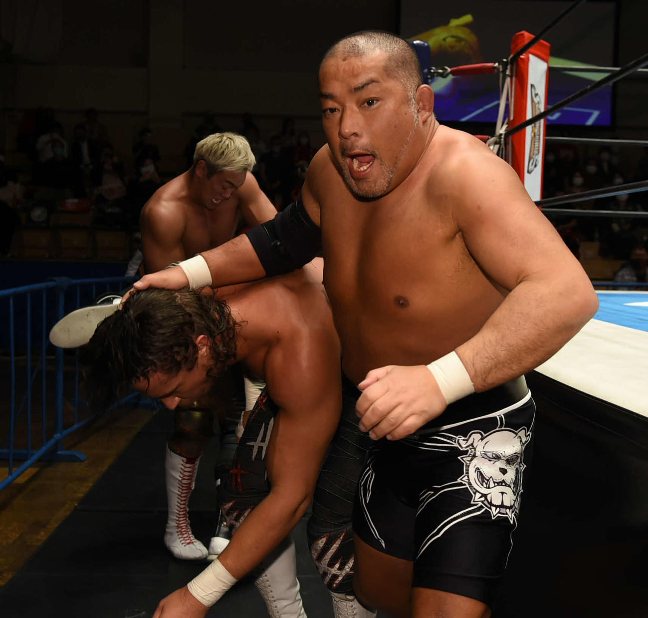 新日本後楽園大会　場外でジェイ・ホワイト（左）の髪をつかむ石井智宏。後方はオカダ・カズチカ（新日本プロレス提供）
