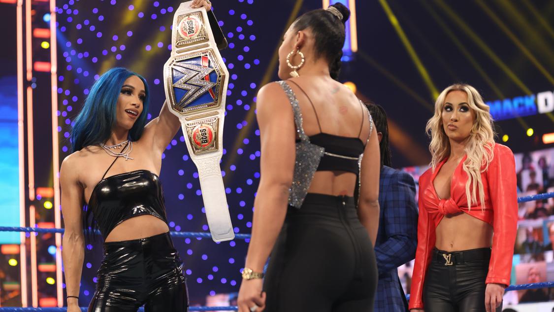 ブレア（中央）にスマックダウン女子王座ベルトを誇示する王者バンクス（左端）。右端はカーメラ（C）2021 WWE, Inc. All Rights Reserved.