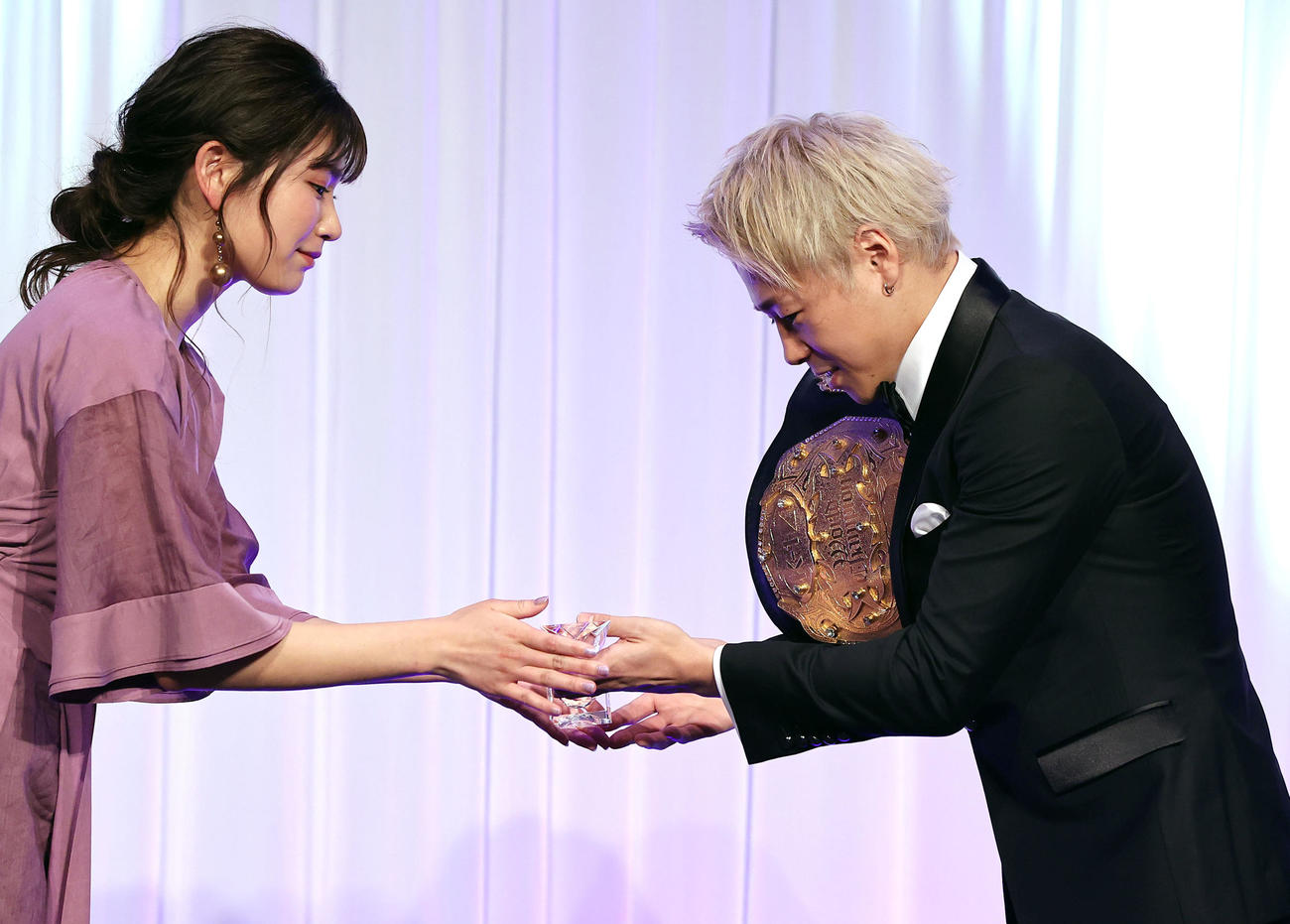 K－1AWARDS2020で、ベストKO賞を受賞した武尊（右）はプレゼンターの久松郁実からトロフィーを受け取る（撮影・浅見桂子）