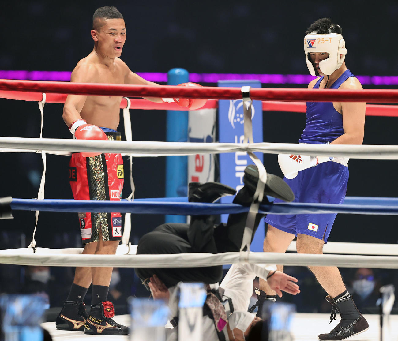 1回、レフェリーを務める渡嘉敷氏（手前下）が倒れ、思わず苦笑する平岡（左）と秋山（撮影・浅見桂子）