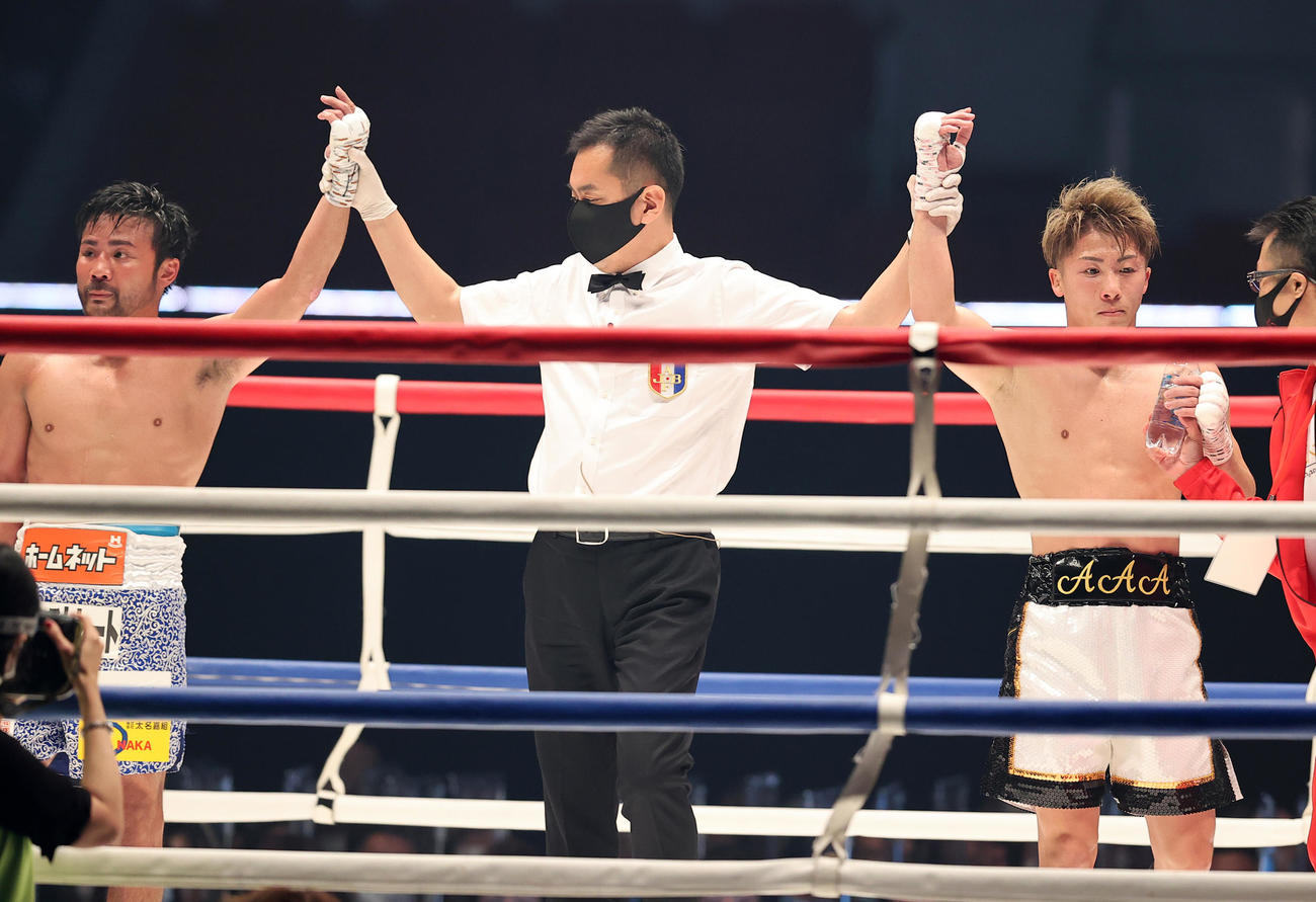 3回を終えて、健闘を称え手を上げる井上（右）と比嘉（撮影・浅見桂子）