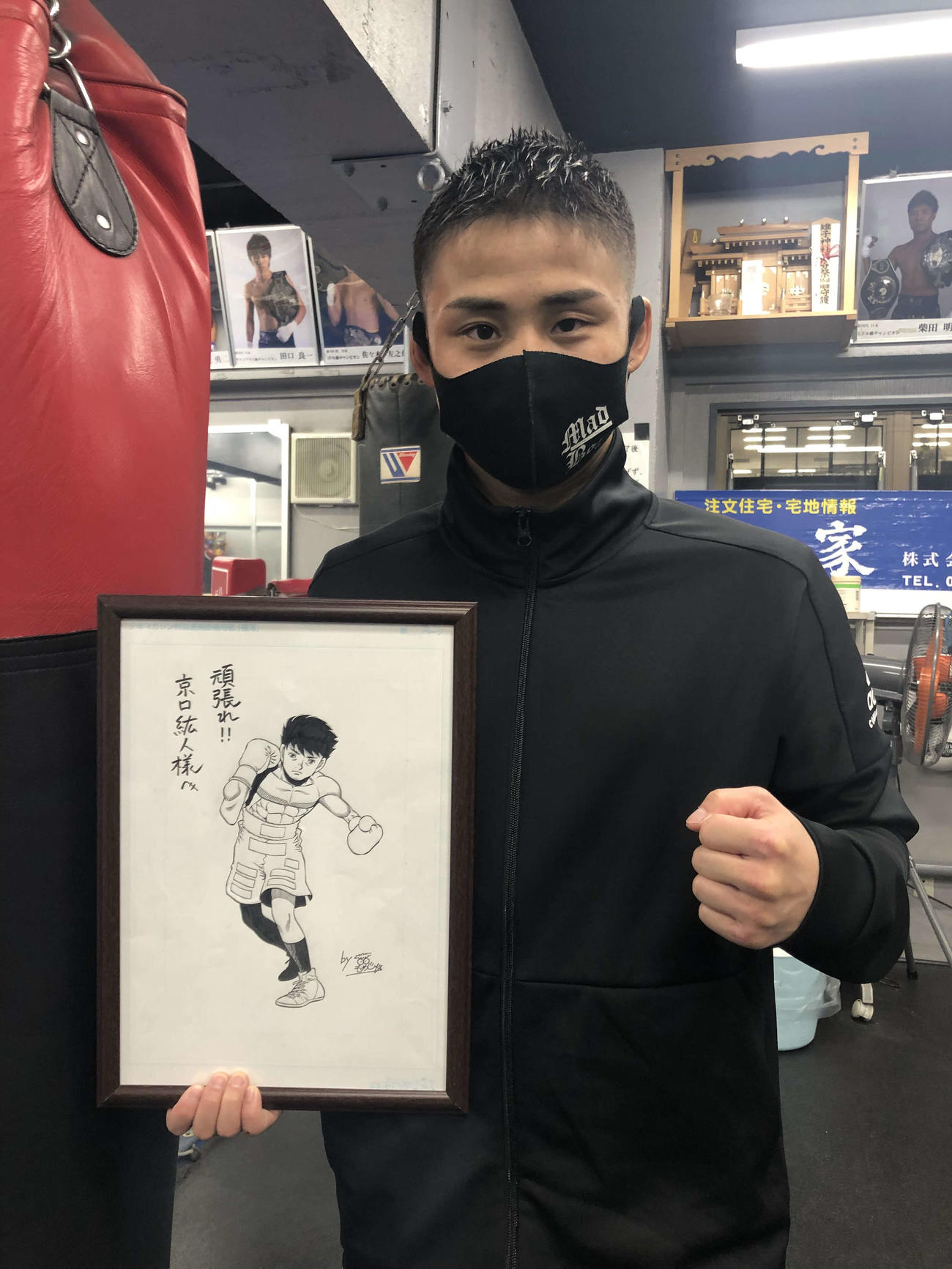 漫画家森川ジョージ氏に描いてもらった自身のイラストを手に笑顔をみせるWBAライトフライ級スーパー王者京口（ABCテレビ提供）