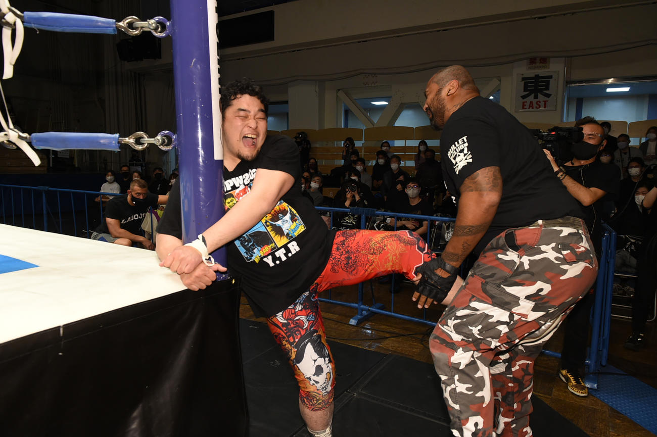 新日本後楽園大会　両手を鉄柱に固定されながらも、バッドラック・ファレ（右）に急所蹴りを浴びせる矢野通（新日本プロレス提供）