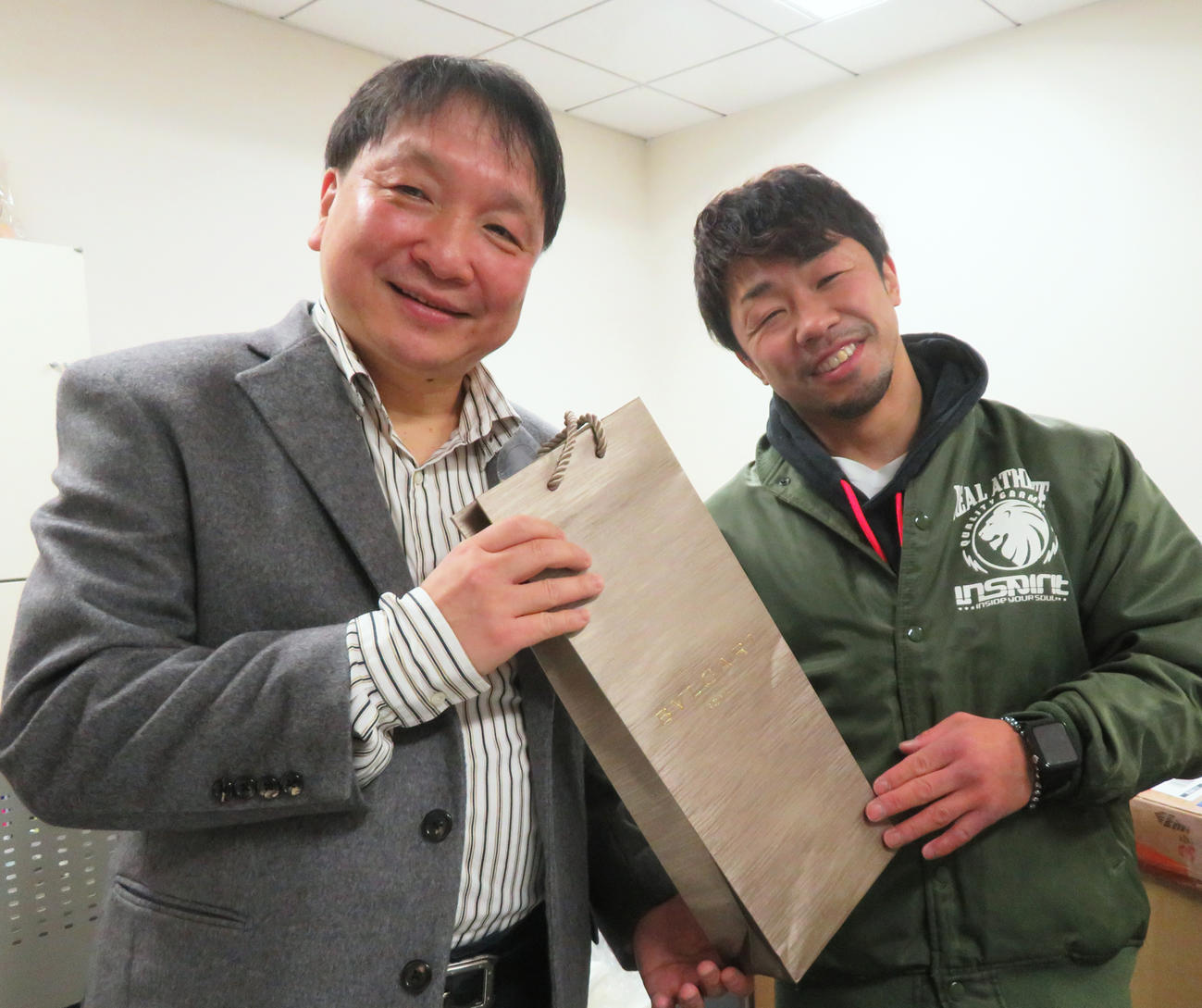 8日に56歳の誕生日を迎え、元世界3階級制覇王者八重樫トレーナー（右）からプレゼントを受け取る大橋会長（撮影・藤中栄二）