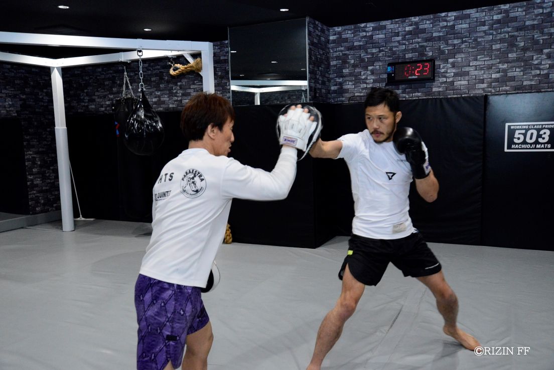 オンラインの公開トレでミット打ちを消化した徳留（右）（C）RIZIN FF