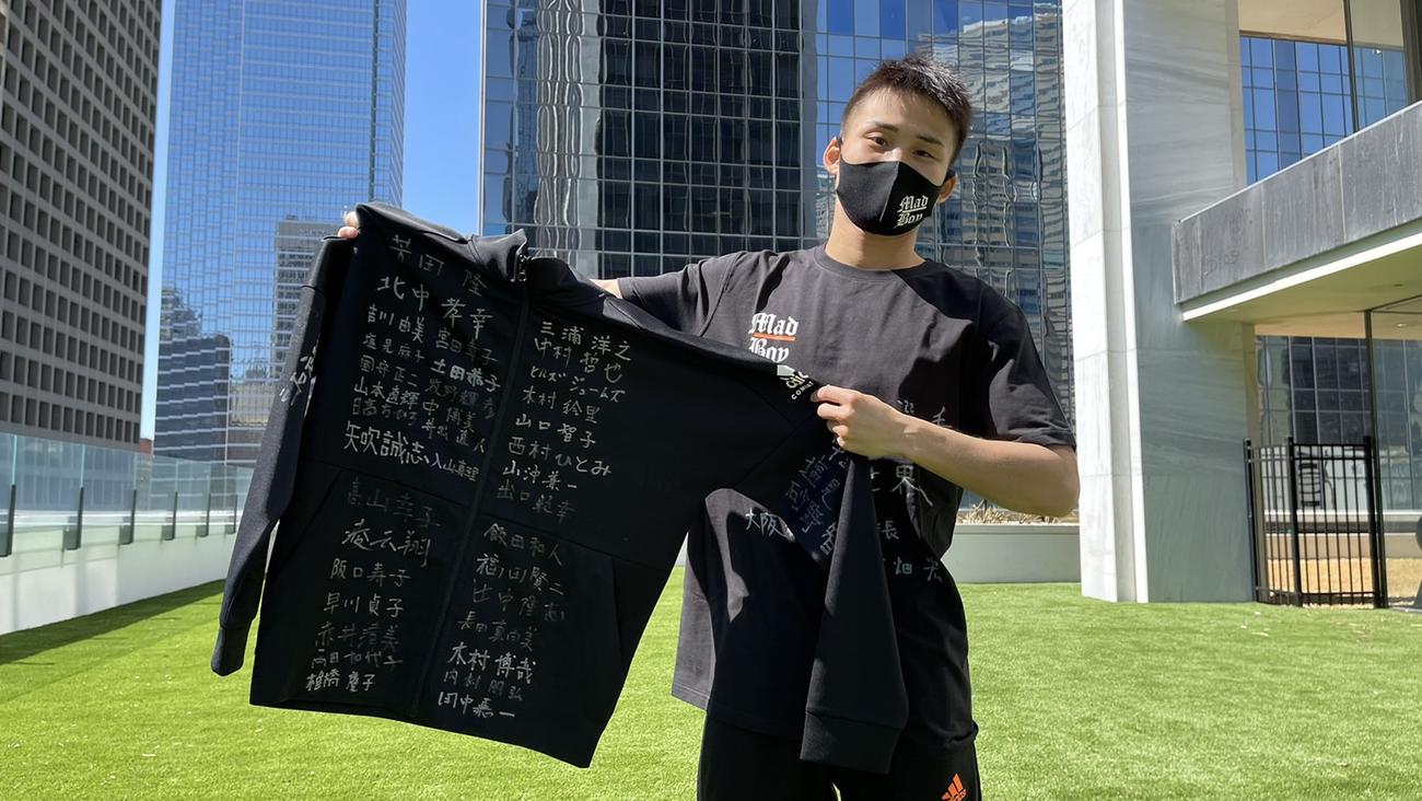 大阪観光局から贈られた寄せ書きTシャツを手にする京口紘人（ワタナベジム提供）