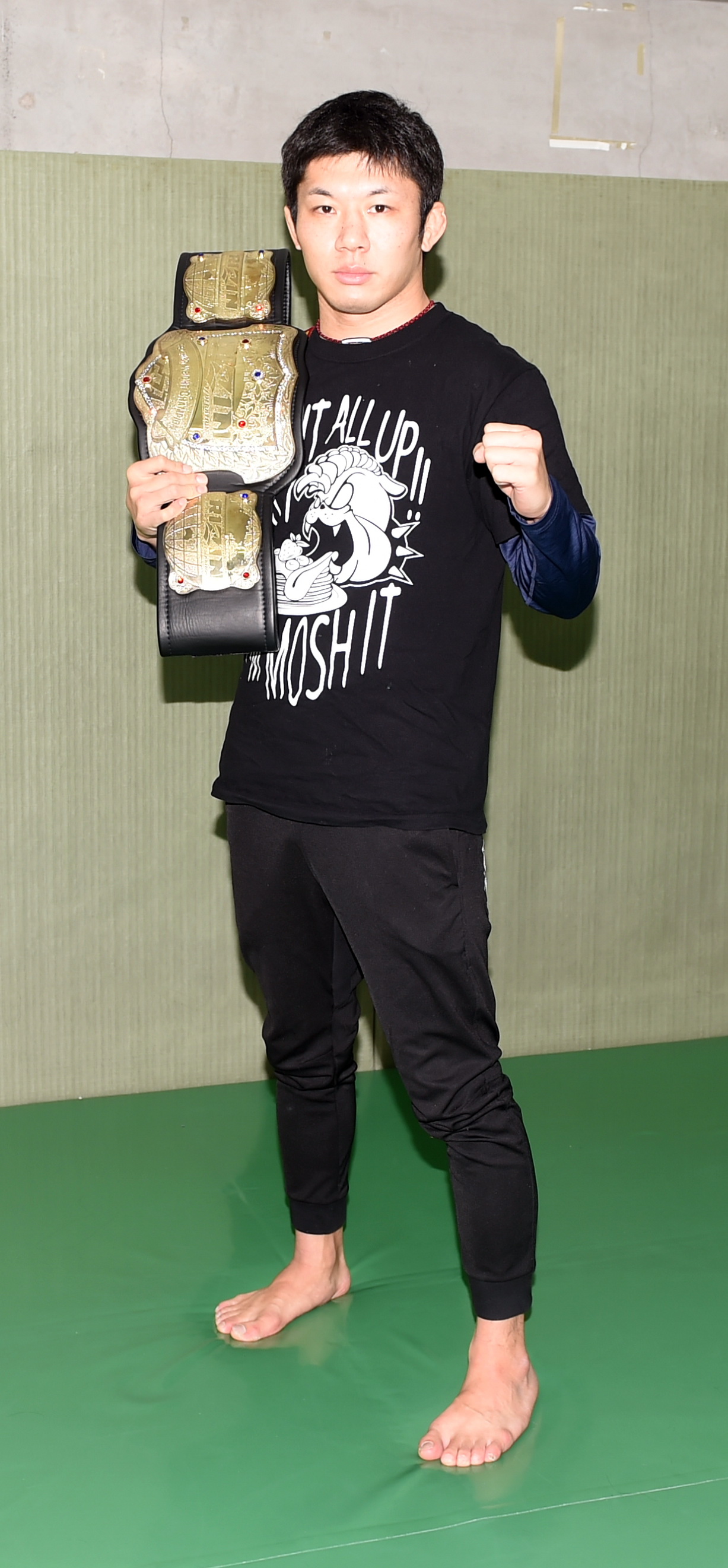 ベルトを肩にかけ、ファイティングポーズを決める斎藤（撮影・山田愛斗）
